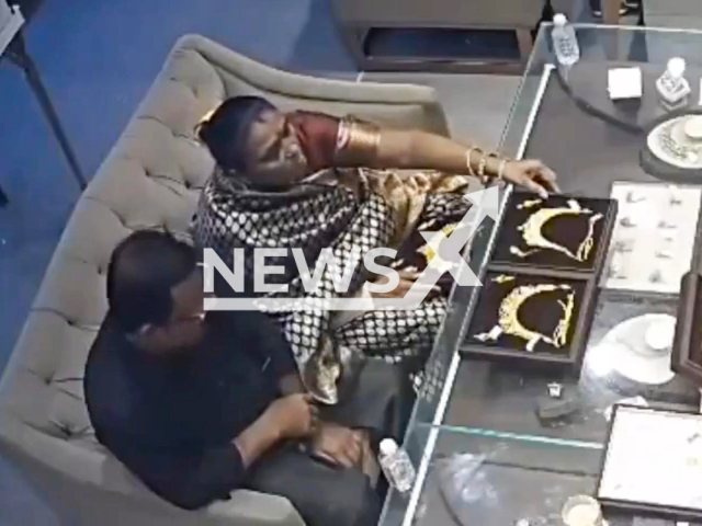 This image is a screen grab of the video supplied titled NewsX-NecklaceSteal-01.mp4: CCTV footage shows a woman posing as a customer at a jewellery showroom stealing a gold necklace by discreetly concealing the necklace under her saree in Bulandshahr, Uttar Pradesh, India on Friday, Sep. 26, 2025.(Clipzilla/NX)