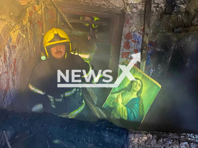 Fireman poses with an icon of Saint Mary, undated. In the fire that engulfed a family house in Senta, Serbia almost everything burned down but the icon was untouched. Note: Police photo. (@mupsrbije/Newsflash)