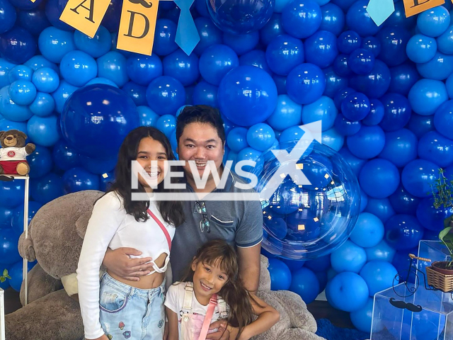 Anibal Okamoto Junior poses with his daughters in undated photo. He drowned after saving them in Matinhos, Brazil. Note: Private photo taken from social media. (Newsflash)