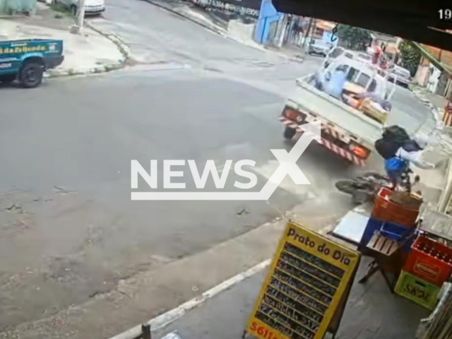 This image is a screen grab of the video supplied titled NewsX-BikerTrucker-01.mp4: Delivery driver narrowly escapes being run over by out-of-control truck in Cidade Ademar, Sao Paulo, Brazil on Friday, Dec. 19. 2025.(Clipzilla)
