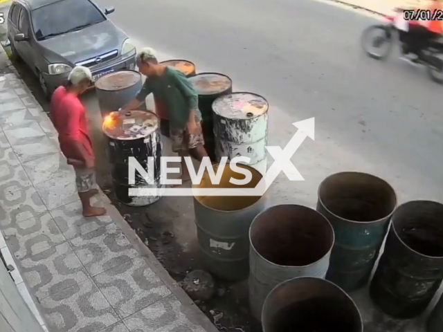 This image is a screen grab of the video supplied titled NewsX-BrozuYobsy-01.mp4: Two young men light a lighter on the lid of a metal barrel and cause an explosion in Recife, Brazil, on 7 January 2026. They suffered injuries.(Clipzilla)