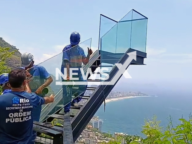 This image is a screen grab of the video supplied titled NewsX-SeifIns-01.mp4: Footage shows workers remove glass staircase due to risk of collapse on Vidigal hill, Rio de Janeiro, Brazil on Tuesday, Jan. 13, 2026.(Clipzilla)