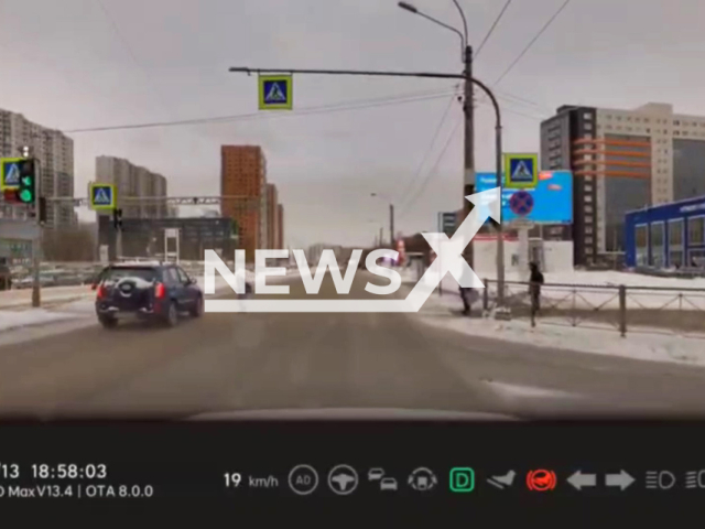 This image is a screen grab of the video supplied titled NewsX-CloseMiss-01.mp4: A schoolchild narrowly avoided being hit by a car at a Saint Petersburg intersection after freezing at the last second as the vehicle swerved past on a slippery road in Saint Petersburg, Russia on Tuesday, Jan. 13, 2026.(Clipzilla)