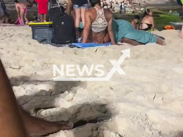 A couple is approached by police officers during what is said to be an oral sex at a crowded beach in Arpoador, Brazil, undated. There were also children around. Note: Photo is a screenshot from the video (Newsflash)