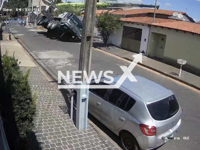This image is a screen grab of the video supplied titled NewsX-TruckCrein-01.mp4:  Security camera footage captures the moment a 90-ton crane lifting a swimming pool suddenly tips, strikes rooftops, and collapses onto multiple houses in Uberlandia, Minas Gerais, Brazil on Friday, Jan. 16, 2026.(Clipzilla)
