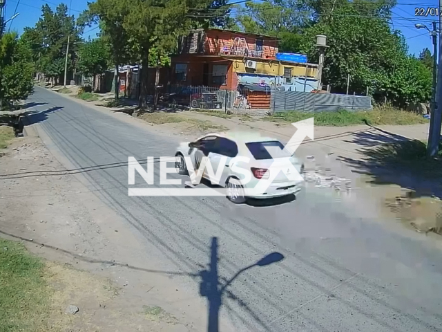 This image is a screen grab of the video supplied titled NewsX-RoberyLift-01.mp4: CCTV shows a failed carjacking as the driver accelerates and drags the suspect clinging to the car window for several blocks in Gonzalez Catan, Buenos Aires Province, Argentina on Thursday, Jan. 22, 2026.(Clipzilla)
