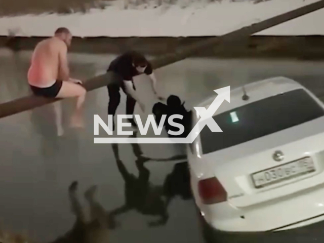 This image is a screen grab of the video supplied titled NewsX-SinkingCar-01.mp4: Footage shows passersby rescuing a mother and child from a sinking car in Makhachkala, Dagestan, Russia on Jan. 24, 2026.(Clipzilla)