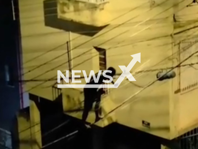 A man balances on overhead wires to steal cables from a utility pole in Belo Horizonte, Brazil. He fled. Note: Photo is a screenshot from the video (Newsflash)