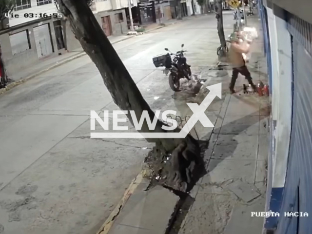 This image is a screen grab of the video supplied titled NewsX-PeruBikes-01.mp4: Footage shows a suspect trying to set fire to a motorcycle shop and ended up engulfed in flames after the attack in Cusco, Peru on Friday, Jan. 23, 2026.(Clipzilla)