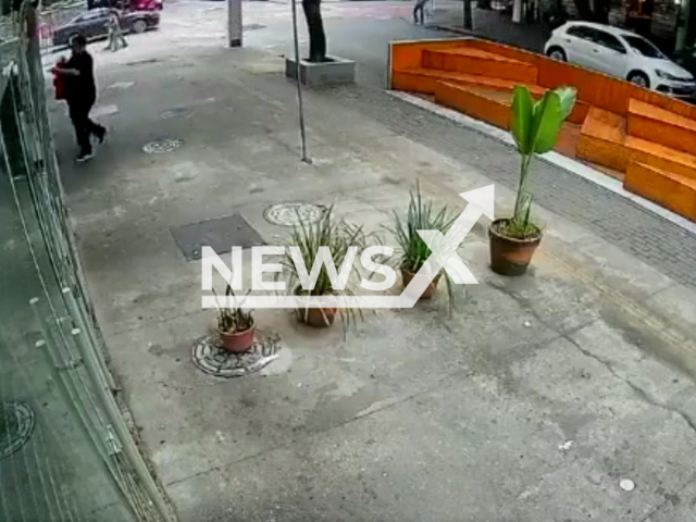 A man escapes an explosion in a restaurant that occurs just as he is about to open the door in Niteroi, Brazil, Monday morning (16 May).  Note: This picture is a screenshot from the video (Newsflash).