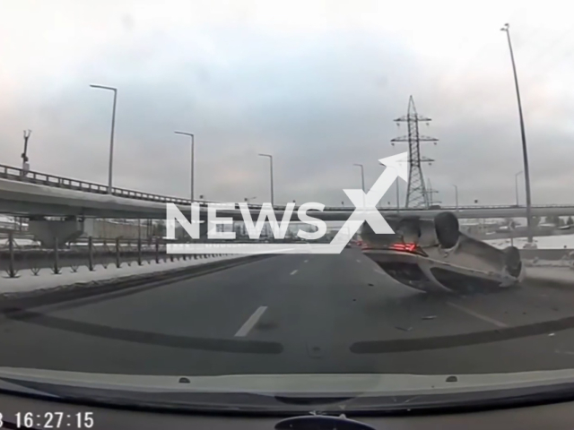 This image is a screen grab of the video supplied titled NewsX-StrikingGuardrail-01.mp4: Footage shows car taxi driver tripped over a guardrail and flipped over on Vitebsky Prospekt, Saint Petersburg, Russia on Wednesday, Jan. 28, 2026.(Clipzilla)