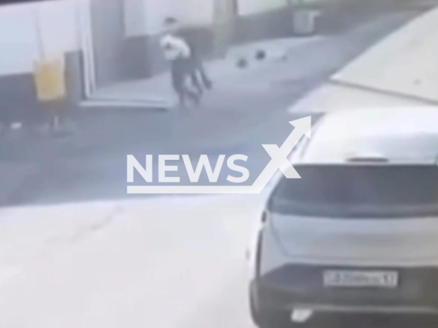 This image is a screen grab of the video supplied titled NewsX-KidnapAttempt-01.mp4: CCTV shows the teenager grabbing the child on the street and trying to take her around the corner in Shymkent, Kazakhstan on Sunday, Feb. 1, 2026 (Clipzilla)