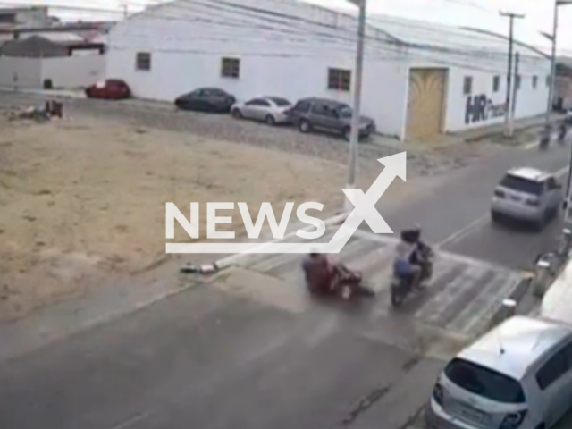 This image is a screen grab of the video supplied titled NewsX-BikerShott-01.mp4: Footage shows man lost control of the motorcycle, skidded, and fell onto the road with the two passengers in Boa Viagem, Ceara, Brazil on Tuesday, Feb. 3, 2026.(Clipzilla)