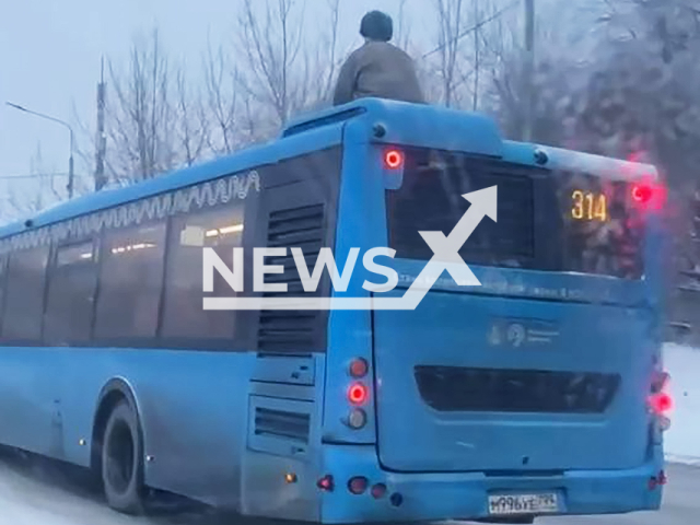 This image is a screen grab of the video supplied titled NewsX-RoofRide-01.mp4: Footage shows a man sitting on the roof of a moving bus in Moscow, Russia on Wednesday, Feb. 11, 2026.(Clipzilla)