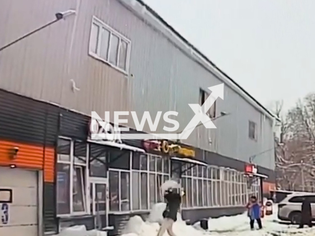 This image is a screen grab of the video supplied titled NewsX-RoofIce-01.mp4: Footage shows girl being struck by a block of ice falling from a roof in Ivanteyevka, Moscow Oblast, Russia on Fri, Feb. 13, 2026.(Clipzilla)