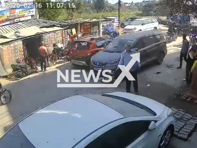 This image is a screen grab of the video supplied titled NewsX-DogAlong-01.mp4: CCTV footage shows a speeding Maruti Suzuki Ertiga running over a leashed pet dog before fleeing the scene in, Kanpur, Uttar Pradesh, India on Monday, Feb. 16, 2026.(Clipzilla)