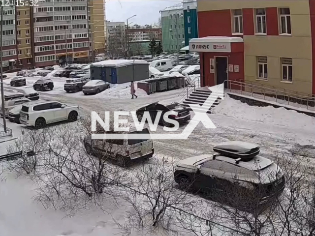 This image is a screen grab of the video supplied titled NewsX-RoofSnow-01.mp4: Footage shows a woman and child nearly struck by snow felling from the roof of a multi-story building in Tyumen, Russia on Tuesday, Feb. 17, 2026.(Clipzilla)