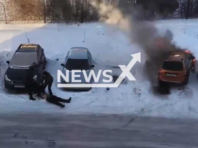 This image is a screen grab of the video supplied titled NewsX-BashkortostanBurningCar-01.mp4: Footage shows a passerby pulling the unconscious driver out of the burning car in Beloretsk, Bashkortostan, Russia on Wednesday, Feb. 25, 2026.(Clipzilla)