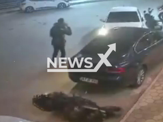 This image is a screen grab of the video supplied titled NewsX-ManTrafficAccident-01.mp4: Footage shows the moment a car lost control in crashing into a waiting motorcyclist and a parked vehicle while a pedestrian talking on the phone narrowly escapes being trapped between the two cars in Emirdag, Afyonkarahisar, Turkey on Thursday, Mar. 5, 2026.(Clipzilla)