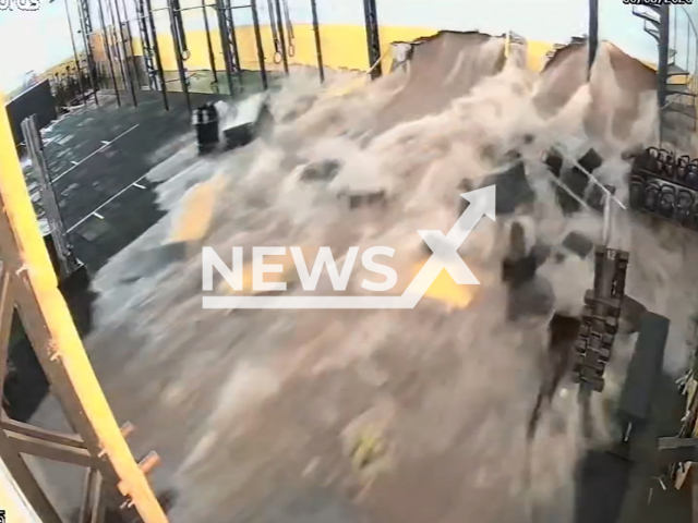 This image is a screen grab of the video supplied titled NewsX-BurningCar-01.mp4: Footage shows the moment the force of the water destroys one of the walls and floods the Yellow Monkey CrossFit building in Saude, Sao Paulo, Brazil on Sunday, Mar. 8, 2026(Clipzilla)