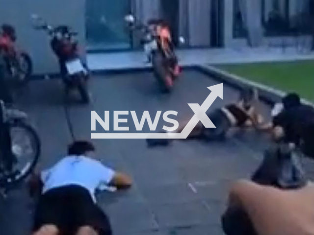 This image is a screen grab of the video supplied titled NewsX-PoolCops-01.mp4: Footage from shows a suspect firing through a window at police during a raid at a pool party before attempting to escape by jumping out of the window as officers returned fire in Esteban Echeverria, Argentina, on Monday, Mar. 9, 2026.(Clipzilla)