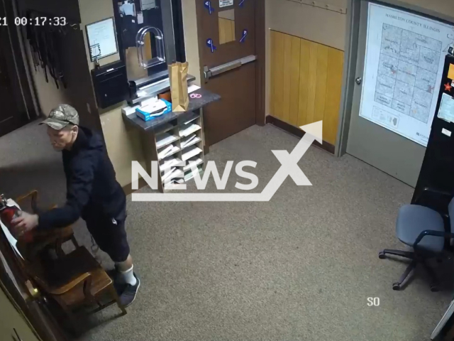 Suspect taking the fire extinguisher off the wall at a sheriff’s office on the 20th October 2021 in Southern Illinois. Note: Picture is a screenshot from a video (Illinois State Police/Clipzilla)