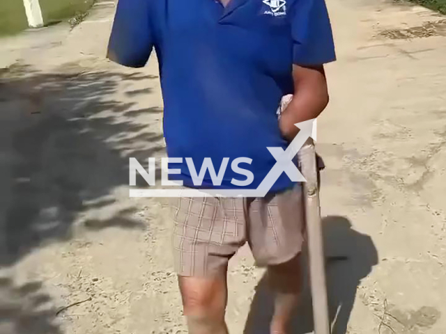 Elderly man walks down the street with a cobra over 2 meters long under his arm in Da Nang City, Vietnam, March 15, 2026. He reportedly carried it home after being bitten.  Note: Photo is a screenshot from a video. (Newsflash)
