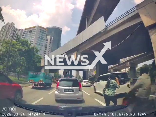 A biker hits a woman crossing the road in Kuala Lumpur, Malaysia, on Mar.24,2026. She was distracted by her mobile phone. Note: Photo is a screenshot from a video. (Newsflash)