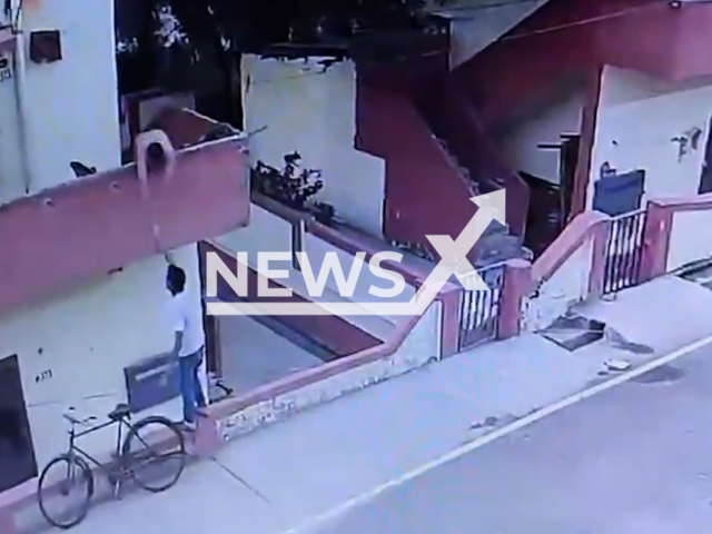 A vendor on the street offers ice cream to a man standing on his balcony in Sonbhadra, India. The man fell and was seriously injured. Note: Photo is a screenshot from a video. (Newsflash/NX)
