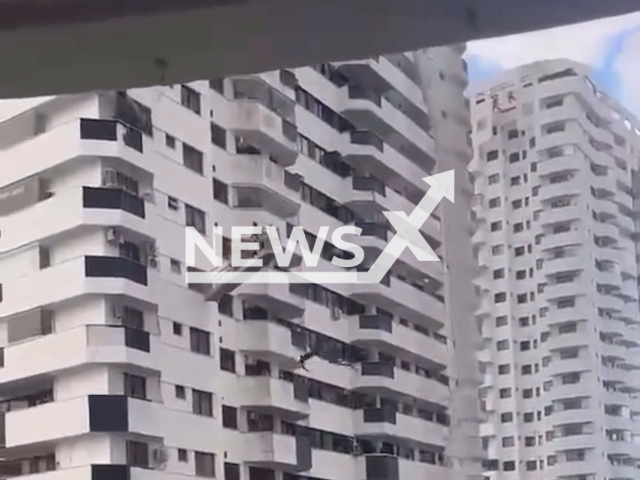 Three workers are trapped on a suspended  scaffolding during strong winds, in Rio de Janeiro, Brazil.  The Fire Department was called to the scene. Note: Photo is a screenshot from a video. (Newsflash/NX)