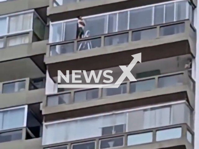 Woman cleans apartment windows on high floor in Barra da Tijuca, Rio in Brazil, undated. Note: Photo is a screenshot from a video. (Newsflash/NX)