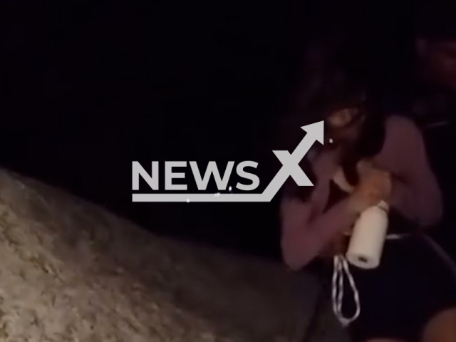 A woman, 27, is rescued from the top of Pedra Furada in Venturosa, Brazil. She climbed up to do a live stream. Note: Photo is a screenshot from a video. (@gcmventurosa/Harrisons)