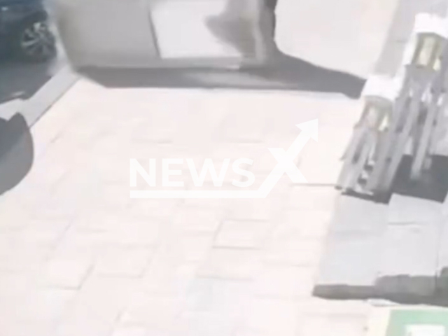 Nujud Thabit, 20, is hit  by falling  PVC door walking on the sidewalk in Karaman, Turkey. Her foot was injured. Note: Photo is a screenshot from a video. (Harrisons)