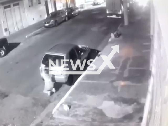 Mother with a child in her arms in the middle of shooting in Cambuci, Brazil in May 2022. Note: Photo is a screenshot from a video(Newsflash).