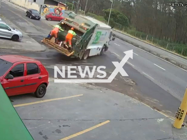 A garbage truck with break issues speeds own the street almost tipping on a turn, as workers hold on, in Mogi das Cruzes, Brail, on 30th May. Note: Picture is a screenshot from a video (Newsflash)