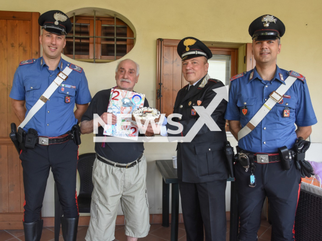 Luciano Caldiero, an 80-year-old retiree from Vicenza, Italy, with police, who he called when he was feeling lonely, and they celebrated his 80th birthday with him. Note: Police photo. (Carabinieri/Newsflash)