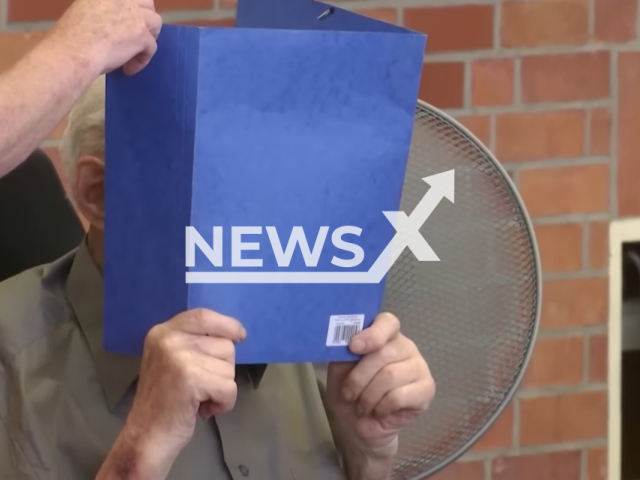 The 101-year-old former concentration camp guard Josef Schuetz hiding his face in the Neuruppin Regional Court in Germany before being sentenced to five years in jail. Note: This photo is a screenshot from a video. (Newsflash)