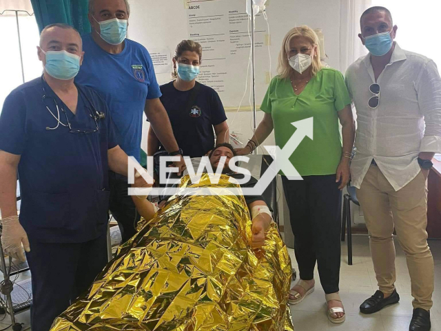 The mayor of Kassandra, Anastasia Chalkia (wearing a green shirt) pictured with Ivan after his rescue and unidentified people in Greece. Note: Photo from mayor. (@anastasiahalkia.d/Newsflash)