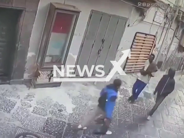 A boy (wearing a blue jacket) walks on the street before being attacked and robbed by two  men in Naples, Italy, in a screenshot from undated footage. 
The robbery took place in May, according to local media. 

 Note: Photo is a screenshot from the video (Newsflash)