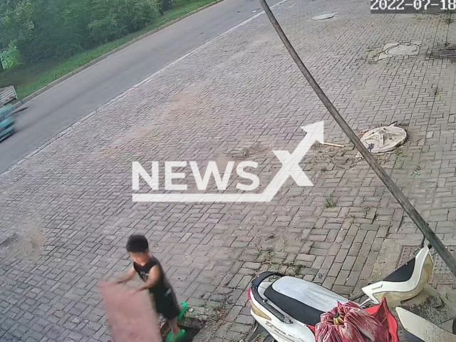 Picture shows a boy falling into a septic tank who was then saved by a woman believed to be his grandmother who jumped in to rescue him in the prefecture-level city of Fuyang in north-western Anhui province, China, on Monday, July 18, 2022. Note: The picture is a screenshot from CCTV footage of the incident. (1138650780/AsiaWire)