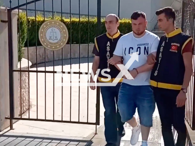 Ethan Lee Hallows, 22, (pictured middle) walks towards police car after getting arrested by police in undated footage. He allegedly killed his father Garry James Hallows, 51, in Mugla, Turkey, Monday, July 25, 2022. Note: Picture is a screenshot from a video (Newsflash)