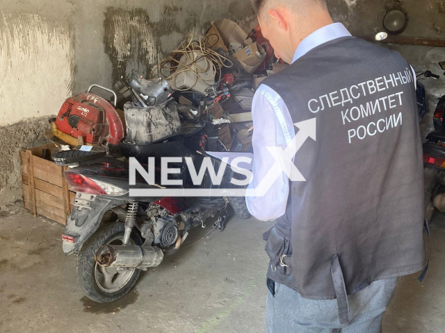 A member of the Main Investigation Department of the Investigative Committee of the Russian Federation for the Republic of Crimea and the city of Sevastopol conducts an investigation in front of a bike used in a crime, in an undated photo. A drunk teenager ran over a traffic police inspector in Sevastopol, Russia, on Tuesday, Aug. 2, 2022. Note: Police photo. (GCU SK RF po Respublike Krym i g. Sevastopolyu/Newsflash)