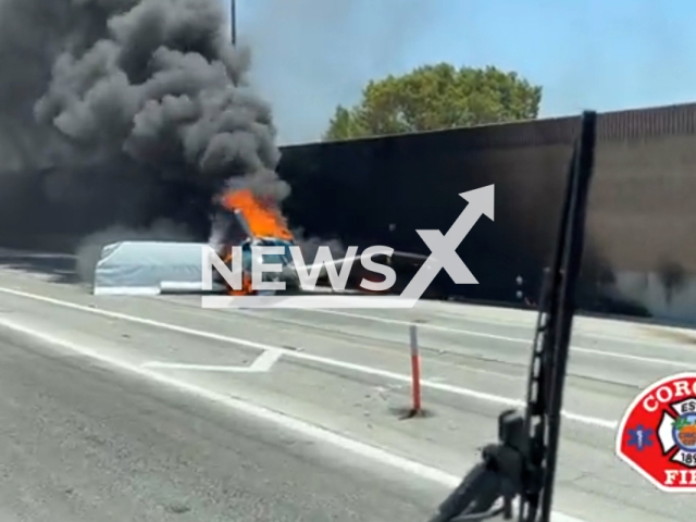 Plane burns after crashing on the 91 Eastbound in Corona, California, on Tue., Aug. 9, 2022. The two occupants were able to safely exit the plane. Note: This picture is a screenshot from the video (@CoronaFireDept/Newsflash).