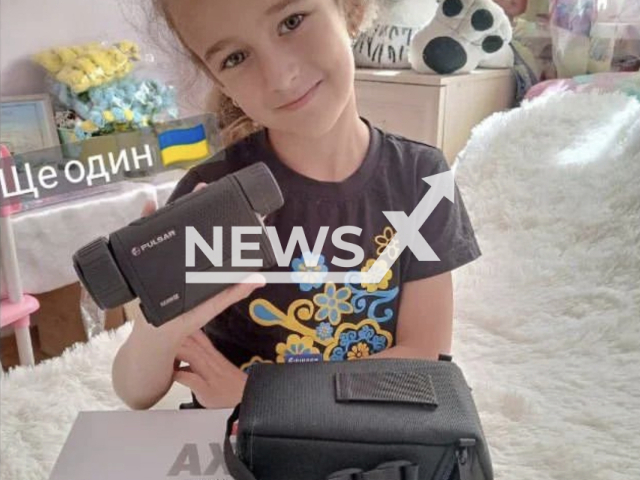 Irynka Vasilyeva, 7, shows unpacked thermal imager and case for it in Ukraine in an undated footage. Her flower crowns sales already helped to buy two thermal imagers and two cars for the Armed Forces of Ukraine. Note: We obtained permission for this photo. ( @vasilevaira1522/Newsflash)