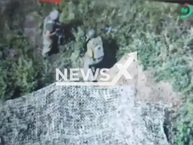 Two  Russian soldiers stand near camouflage net tent in the forest area of Donetsk region, Ukraine in an undated photo.  Fighters of the 14th separate mechanized brigade named after Prince Roman the Great claimed they destroyed three Russian tanks and approximately 25 Russian occupiers. Note: Photo is a screenshot from the video (@14ombr/Newsflash)