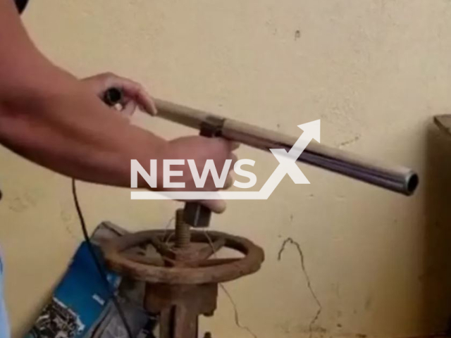 A police officer with the safety device built by a shop owner, in Araxa, Brazil, undated.  The  60-year-old mechanic died from the device he made to protect a mechanic shop he owned  on Saturday, Aug. 20, 2022.
Note: Police photo. (Policia Civil/Newsflash)