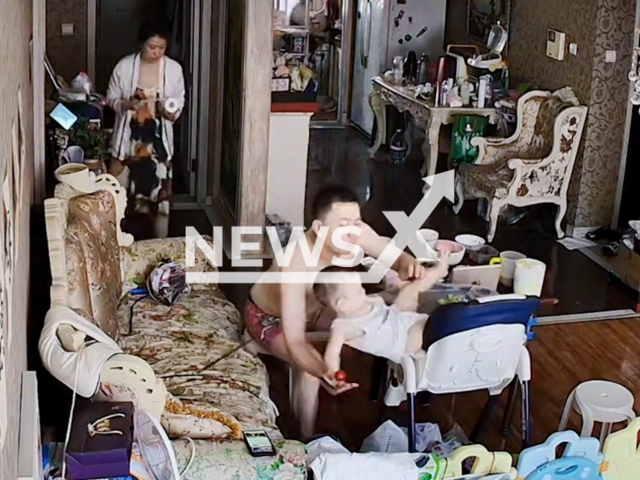 Dad rescues baby from falling off a chair with a quick reaction in Changchun, Jilin Province in China, in undated footage. The baby was standing on a chair next to his dad who was having a meal. Note: Picture is a screenshot from a video (Zhifen_yang86/AsiaWire)