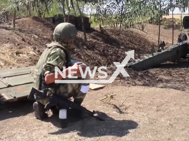 Russian soldier holds missile for Giatsint-B howitzer in Ukraine in undated footage. Units of the Russian Airborne Forces destroyed Ukrainian positions of artillery and infantry with help of Giatsint-B howitzers. Note: Picture is a screenshot from a video (@mil/Newsflash)