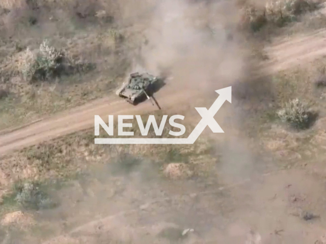 Ukrainian tank goes down the road in a field area near the village of Pervomaiske, Ukraine in undated footage. Fighters of the 11th regiment of the NM of the DPR destroyed Ukrainian tank. Note: Picture is a screenshot from a video (@nm_dnr/Newsflash)