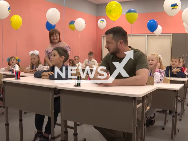 The president of Ukraine Volodymyr Zelensky sits by the school table with kids in Irpen, Ukraine, Thursday, Sep. 1, 2022. Volodymyr Zelensky visited rebuilt after the hostilities Irpen school and congratulated the first-graders and their teachers on the Day of Knowledge. Note: Picture is a screenshot from a video (@zelenskiy.official/Newsflash)